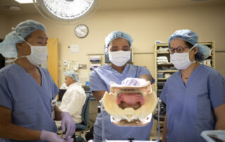 Surgeons practicing pelvic surgery on a Miya Model.